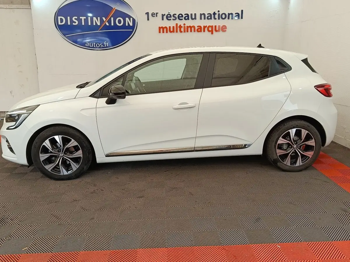 Profil droit d'une Renault Clio blanche 2023 Evolution TCe 100 GPL avec jantes alliage et rétroviseurs noirs.