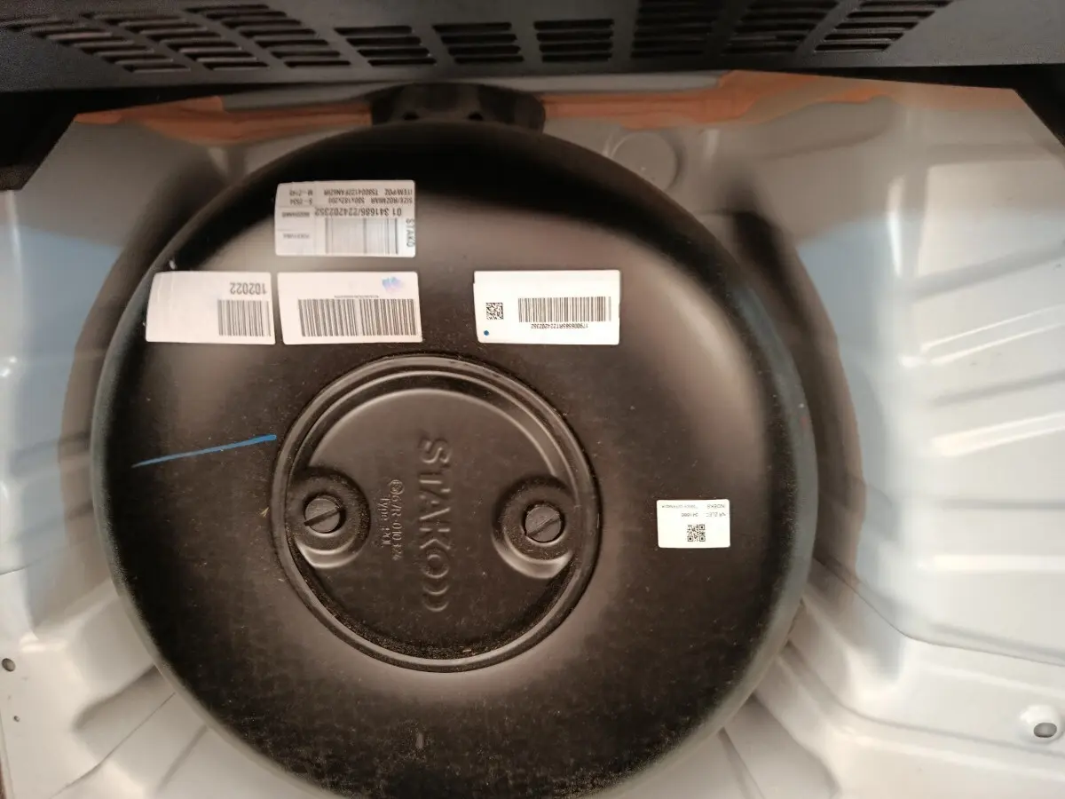 Vue rapprochée du réservoir GPL noir circulaire dans le coffre d’une Renault Clio blanche Evolution TCe 100 GPL.