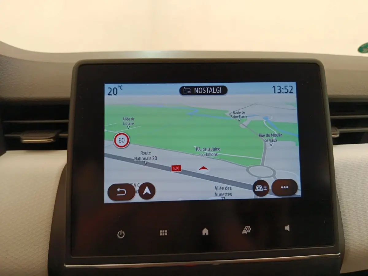 Écran tactile central affichant la navigation 3D dans l'habitacle clair d'une Renault Clio blanche.