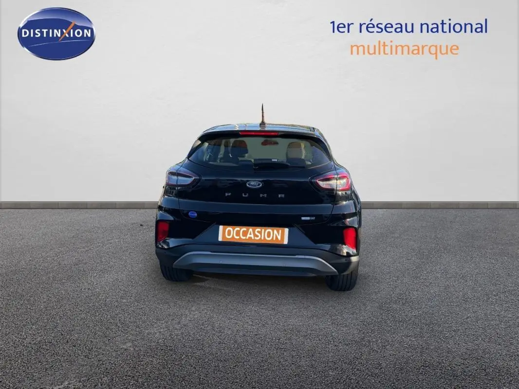 Vue arrière d'un Ford Puma noir 2023 avec feux allumés sur fond neutre, plaque "OCCASION" visible.