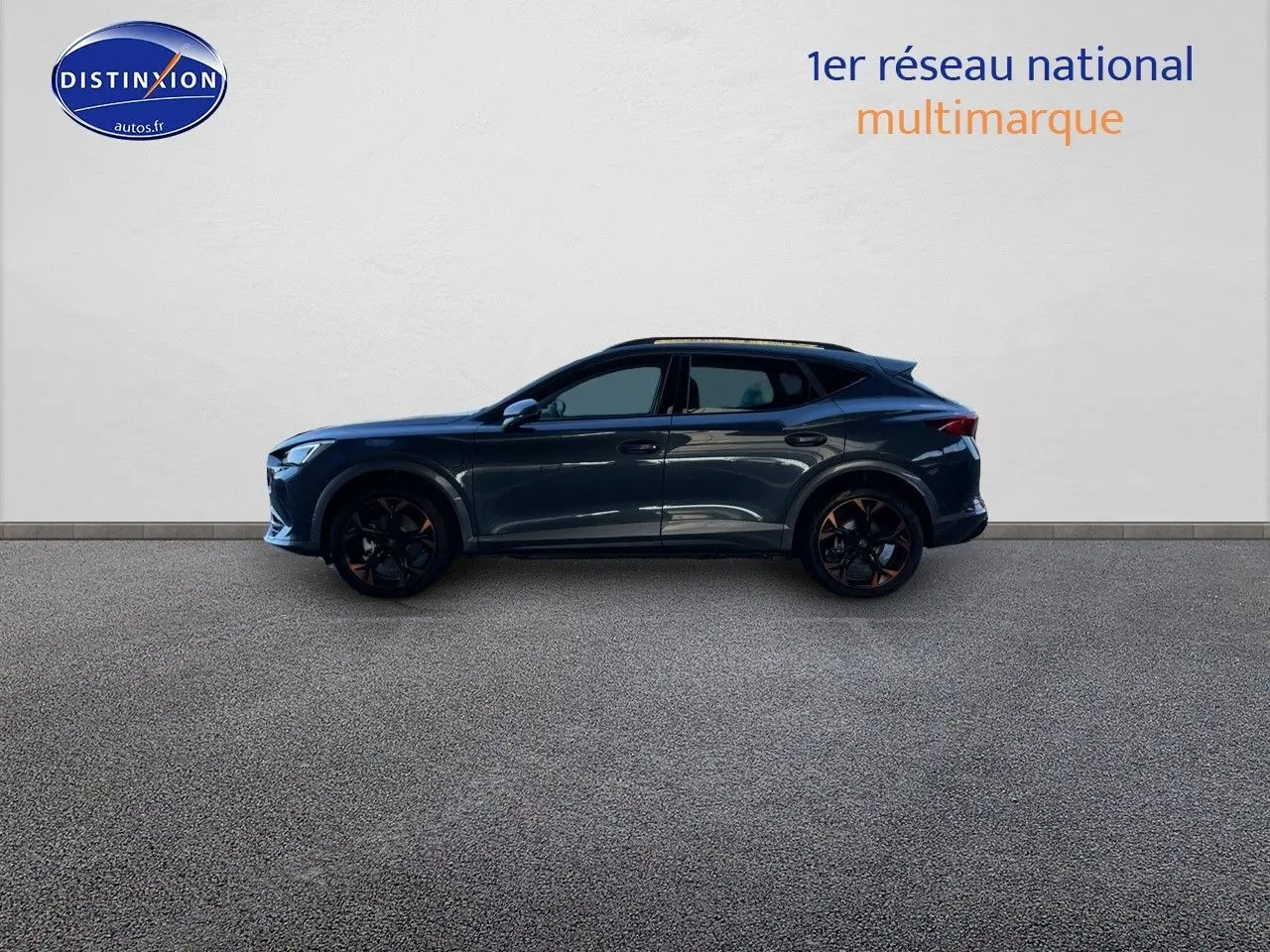 Profil droit d'un CUPRA Formentor gris magnétique 2024 avec jantes noires et détails cuivrés, sur fond neutre intérieur.