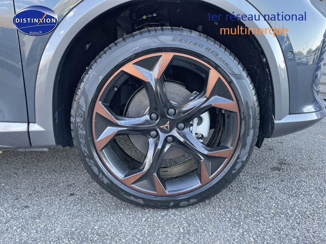 Gros plan sur la roue avant droite du CUPRA Formentor gris magnétique, mettant en valeur la jante noire et cuivrée au design sportif.