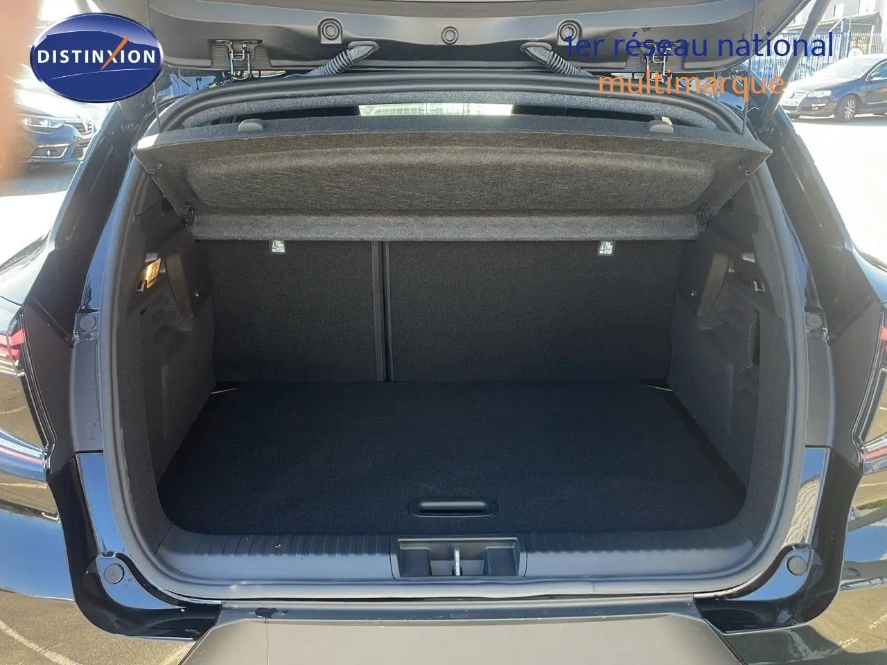 Coffre ouvert d'un Renault Captur E-Tech hybride noir étoile métal, vue arrière montrant l'espace de chargement vide.