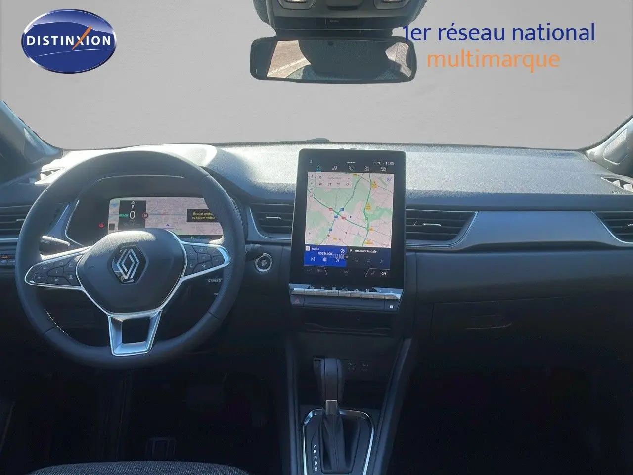 Vue intérieure du tableau de bord du Renault Captur E-Tech hybride 2025 avec écran tactile central et volant multifonction noir.