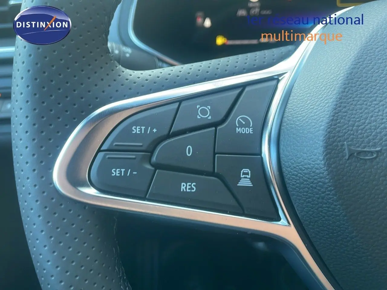 Gros plan sur les commandes de régulateur de vitesse au volant perforé du Renault Captur E-Tech hybride noir étoile métal 2025.