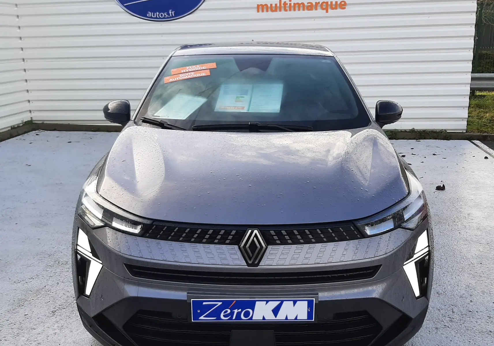 Vue de face du Renault Captur gris Cassiopée 2025 avec calandre moderne et feux LED distinctifs allumés.