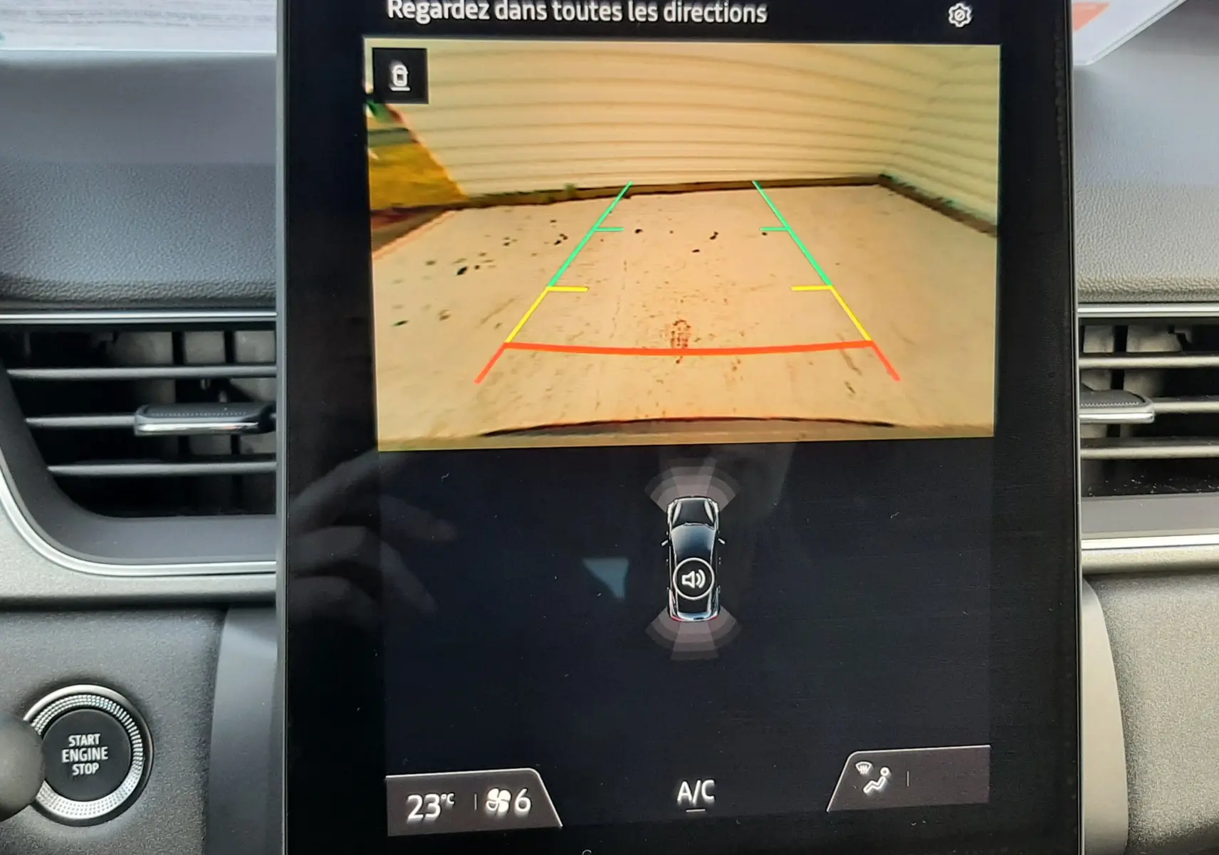 Écran central du Renault Captur 2025 montrant la caméra de recul avec lignes de guidage colorées, intérieur noir visible.