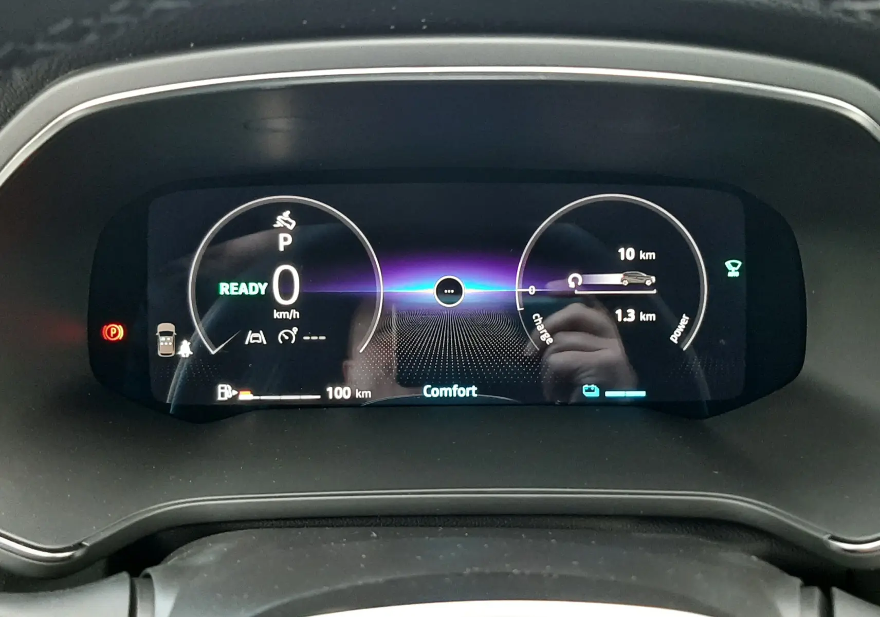 Vue rapprochée du tableau de bord numérique du Renault Captur gris Cassiopée 2025, affichant la vitesse et l'autonomie hybride.