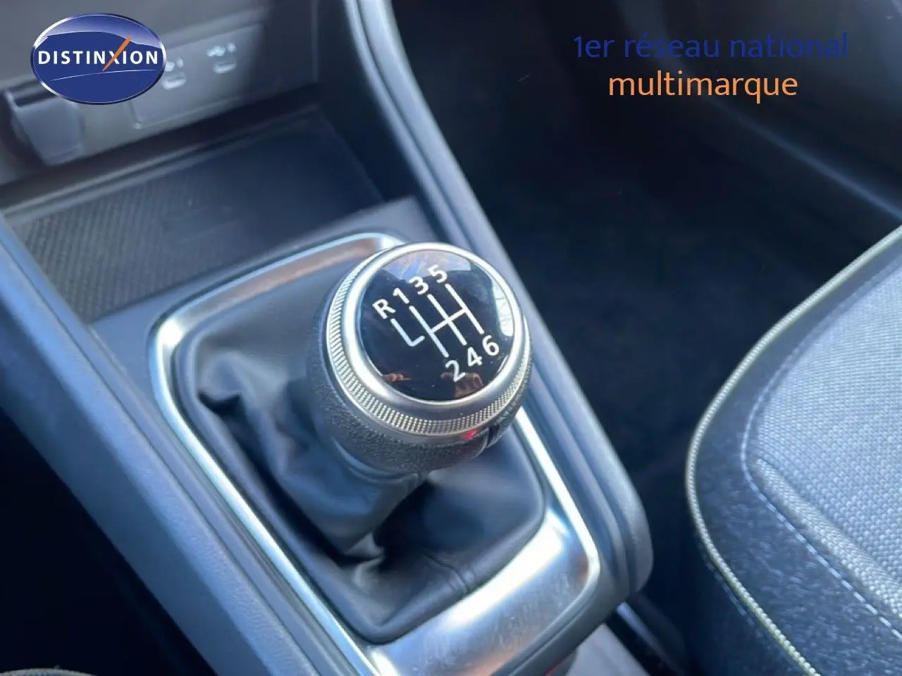 Gros plan sur le levier de vitesses manuel du Renault Captur 2025, entouré de garnitures noires et tissu gris du siège.