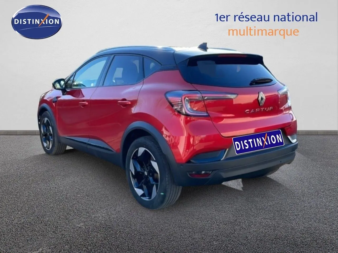 Vue 3/4 arrière droite d'un Renault Captur rouge Désir Métal avec toit noir et jantes noires brillantes.