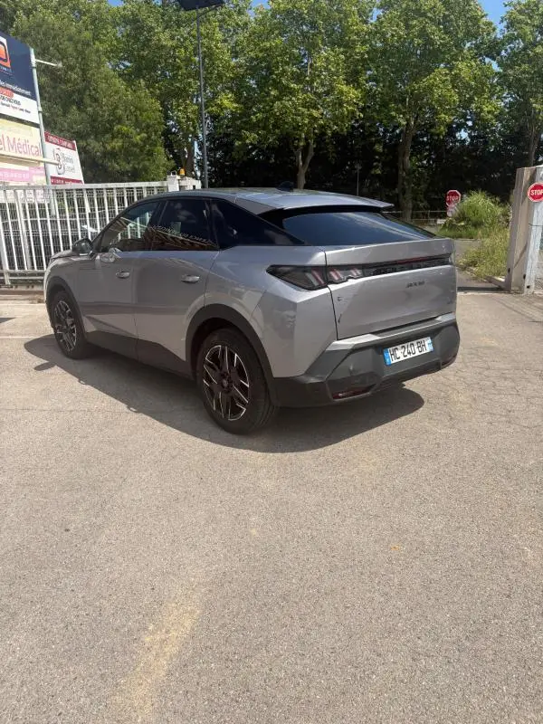 Peugeot 3008 Hybrid gris clair vue 3/4 arrière droit, toit noir et jantes alliage noires visibles.