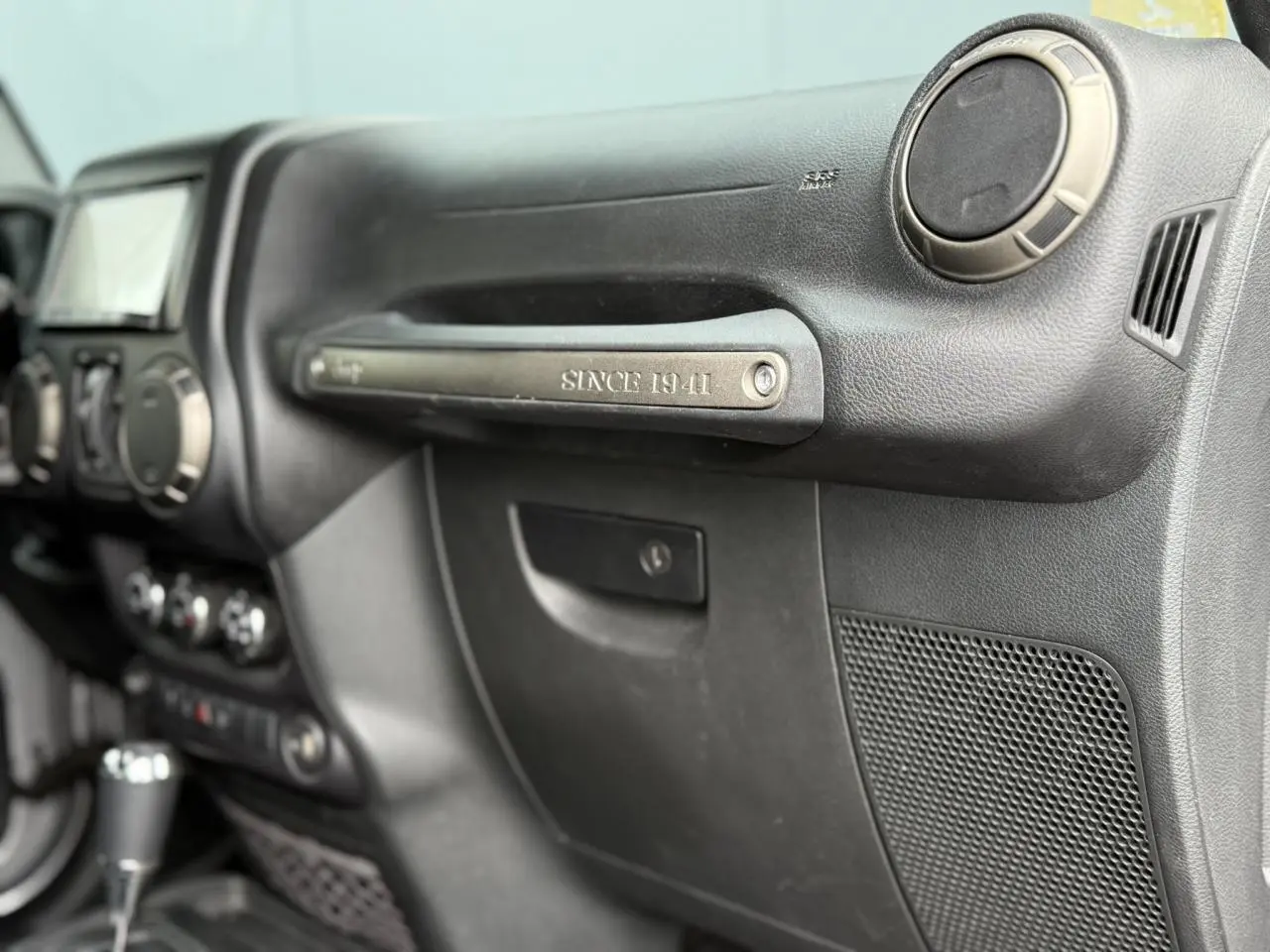 Vue intérieure côté passager du tableau de bord noir de la Jeep Wrangler 2019 avec poignée "Since 1941" visible.