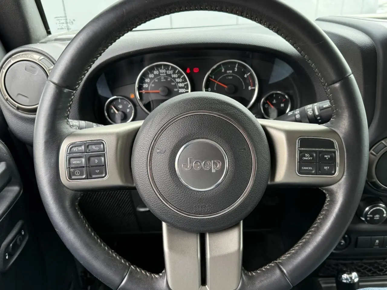 Volant cuir Jeep avec commandes multifonctions, tableau de bord et compteurs visibles en arrière-plan intérieur Wrangler 2019.