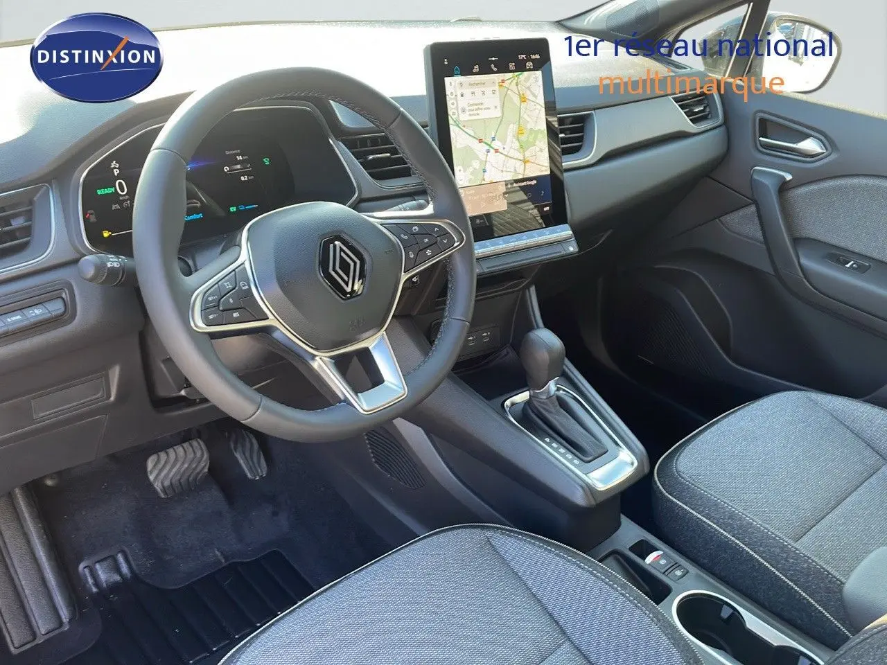 Intérieur du Renault Captur E-Tech hybride 2025, vue côté conducteur sur le volant, écran tactile et console centrale.