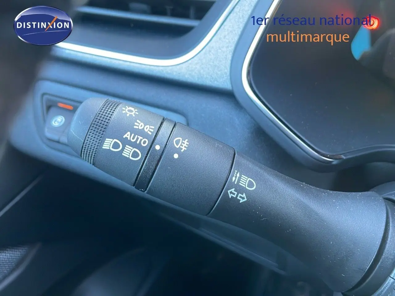 Gros plan sur la commande des feux et clignotants dans l'habitacle du Renault Captur blanc nacré 2025.