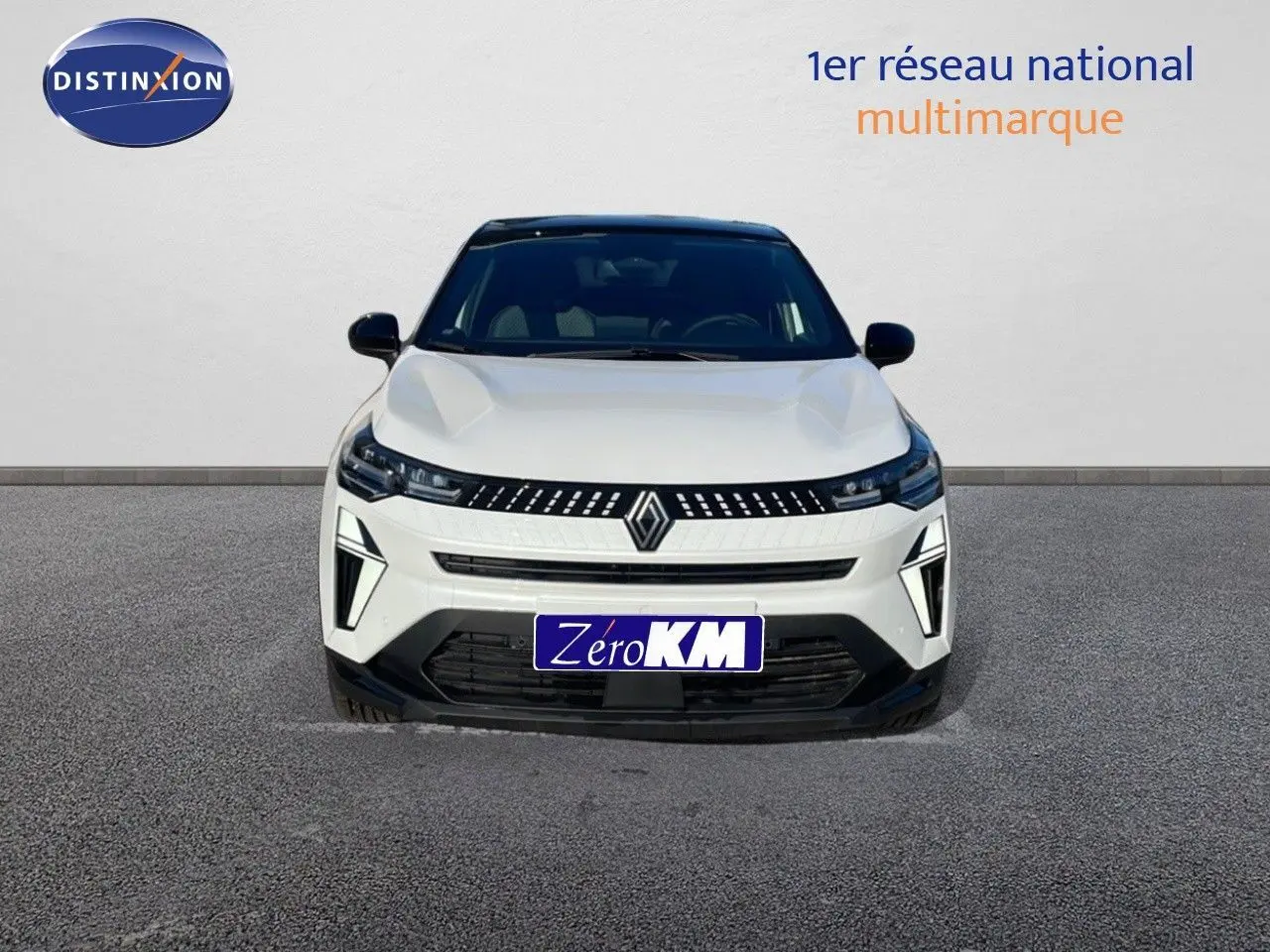 Vue frontale d'un Renault Captur E-Tech hybride blanc nacré avec toit noir, calandre moderne et phares LED distinctifs.