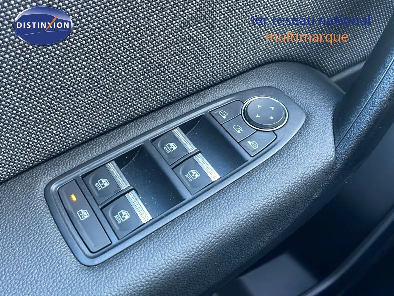 Gros plan sur les commandes des vitres électriques côté conducteur d’un Renault Captur blanc nacré 2025.