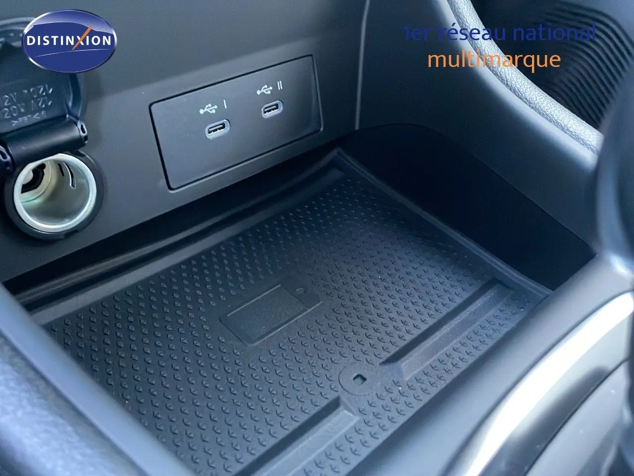 Gros plan sur la console centrale du Renault Captur 2025 avec prise USB double et tapis de rangement noir.