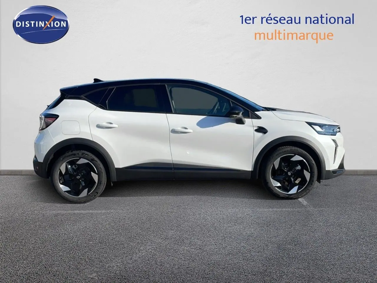 Profil côté gauche d'un Renault Captur E-Tech hybride blanc nacré avec toit noir et jantes noires 18 pouces.