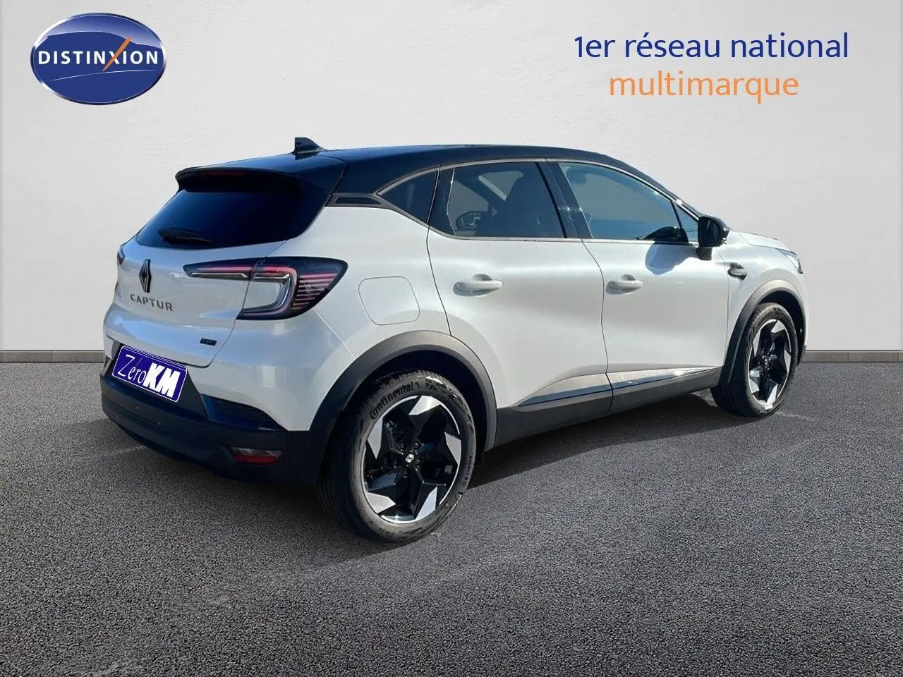 Renault Captur E-Tech hybride blanc nacré avec toit noir, vue 3/4 arrière côté droit, jantes noires distinctives.