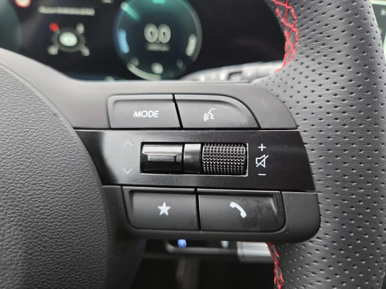 Gros plan sur les commandes gauche du volant perforé noir avec surpiqûres rouges du Hyundai Tucson N Line 2025.