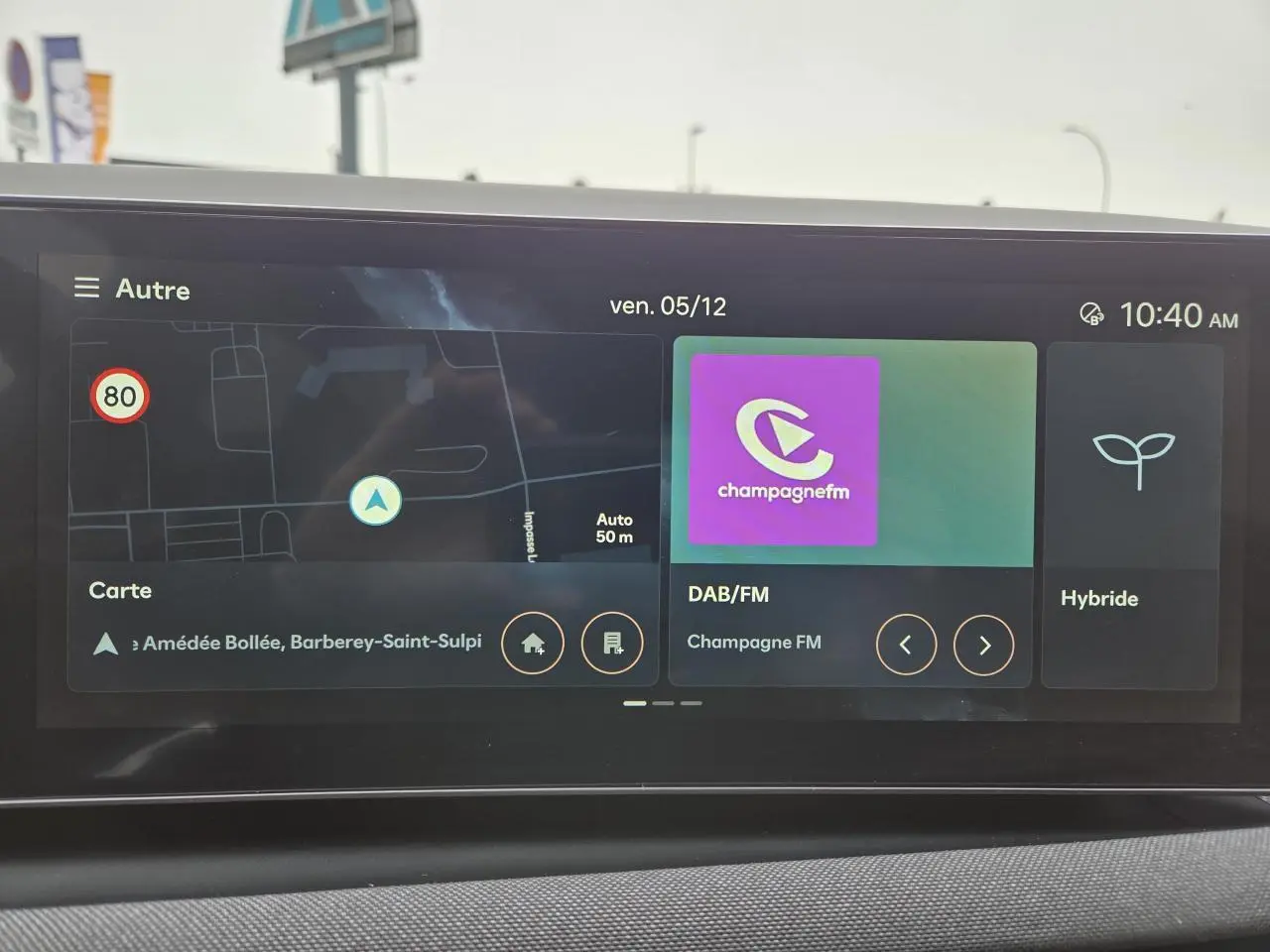 Écran tactile intérieur du Hyundai Tucson 2025 affichant navigation, radio DAB/FM et mode hybride.
