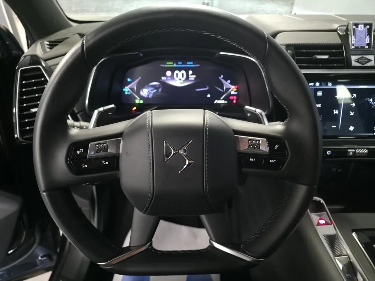 Vue centrée sur le volant cuir noir du DS7 Crossback 2024 avec tableau de bord numérique et commandes intégrées.
