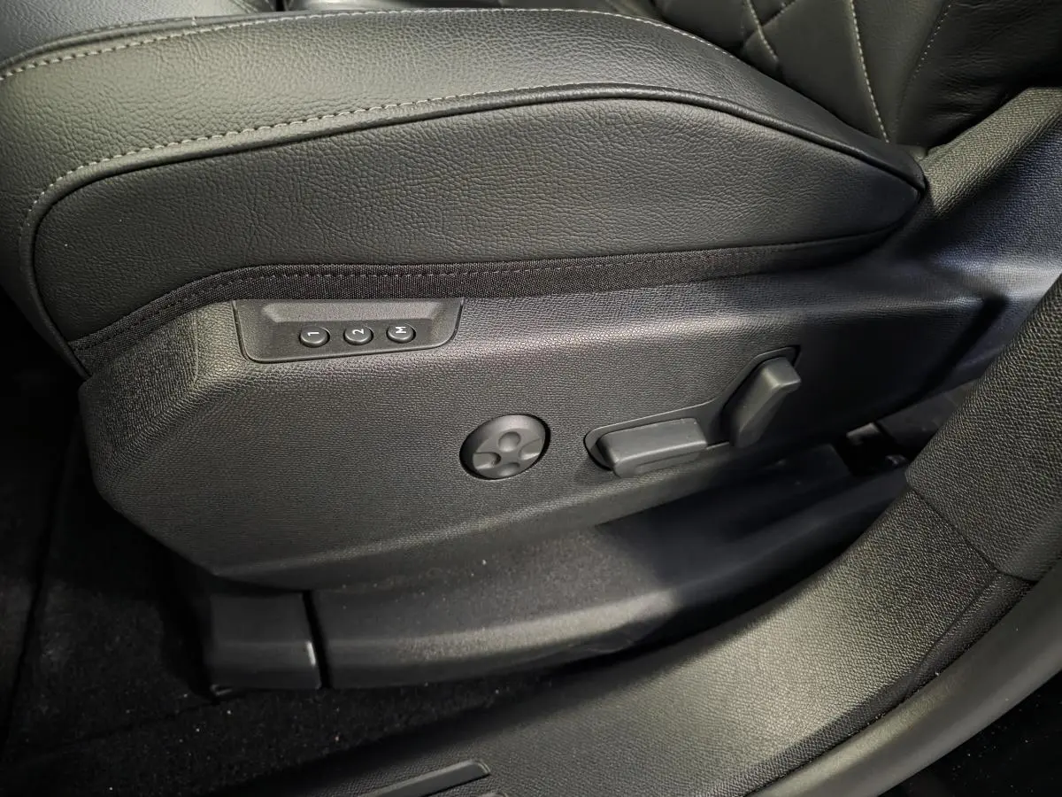 Détail côté gauche du siège avant en cuir noir avec commandes électriques de réglage sur DS7 Crossback 2024.