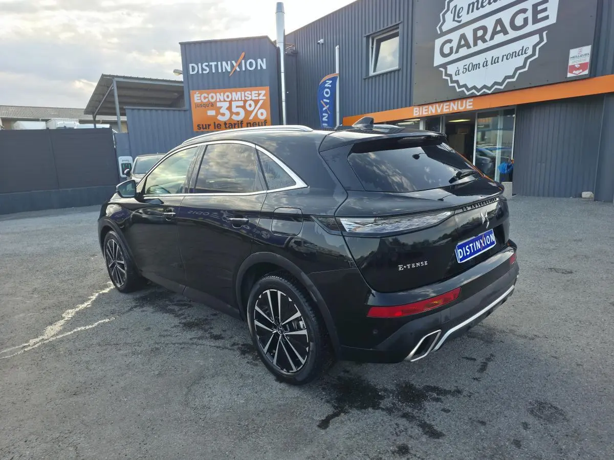 Vue 3/4 arrière droite du DS7 Crossback E-Tense noir métallisé avec jantes 19'' et double sorties d’échappement chromées.