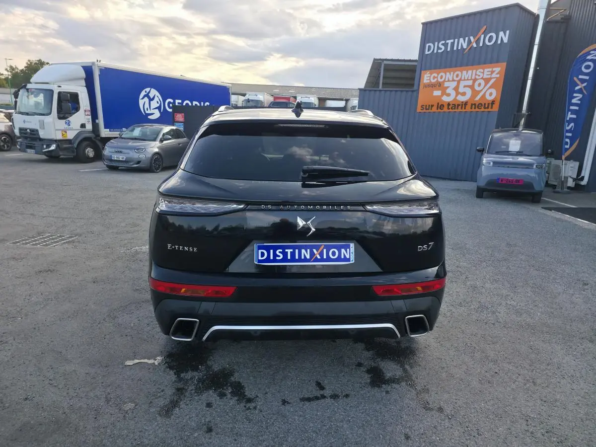 Vue arrière d'un DS7 Crossback E-Tense noir avec feux arrière 3D et double sorties d'échappement chromées.