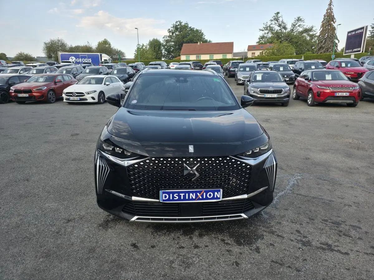 Vue avant d'un DS7 Crossback E-Tense noir avec calandre DS Wings et feux LED distinctifs sur un parking.