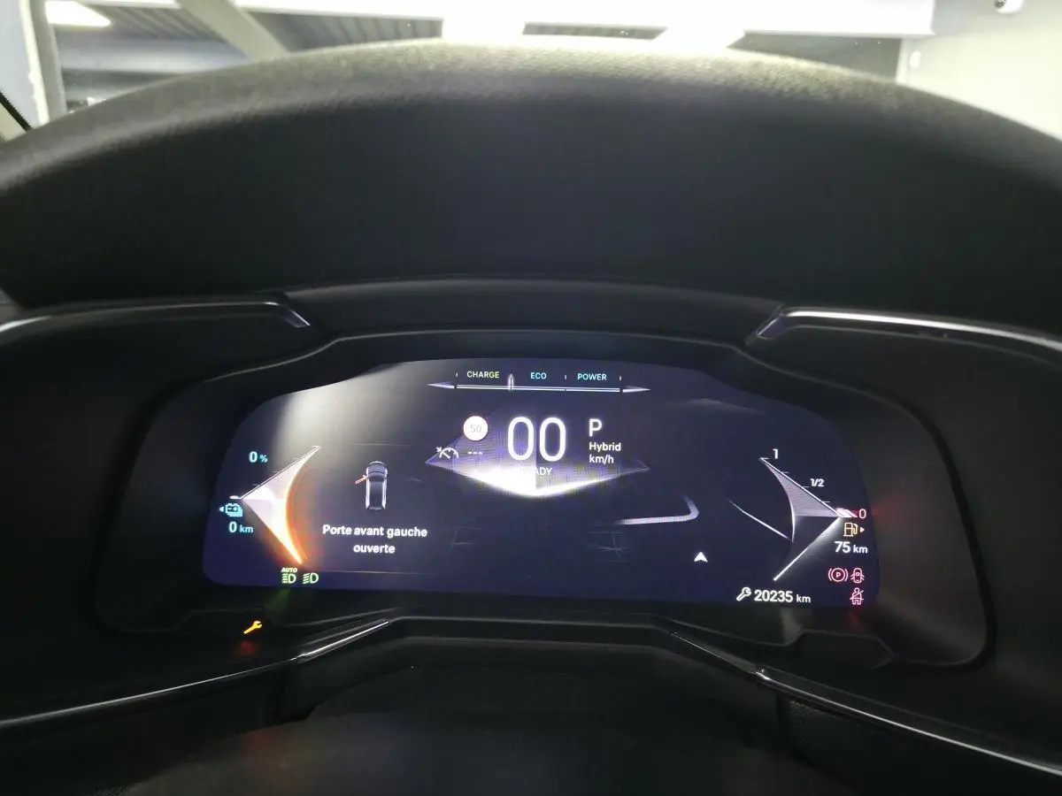Vue rapprochée du tableau de bord numérique du DS7 Crossback noir, affichant porte avant gauche ouverte et indicateurs hybrides.