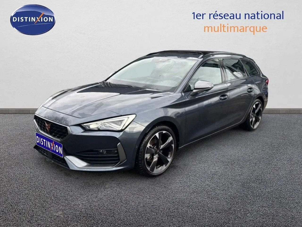 Vue 3/4 avant d'une CUPRA Leon ST 2024 gris magnétique métal avec jantes alliage bicolores et calandre distinctive.