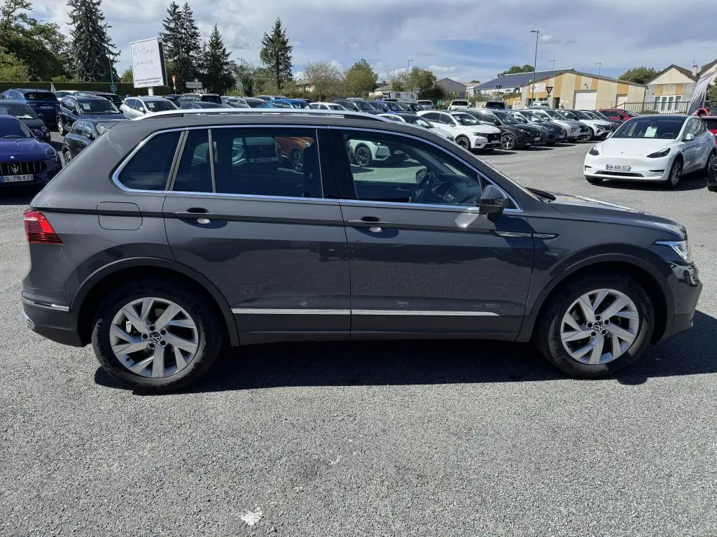 Profil côté gauche d'un Volkswagen Tiguan gris Urano 2021, avec jantes alliage 18 pouces et vitres surteintées.