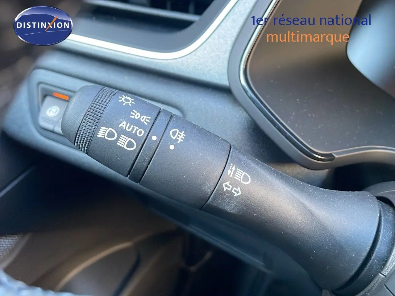 Gros plan sur la commande des feux et clignotants dans l'habitacle du Renault Captur E-Tech gris cassiopée.