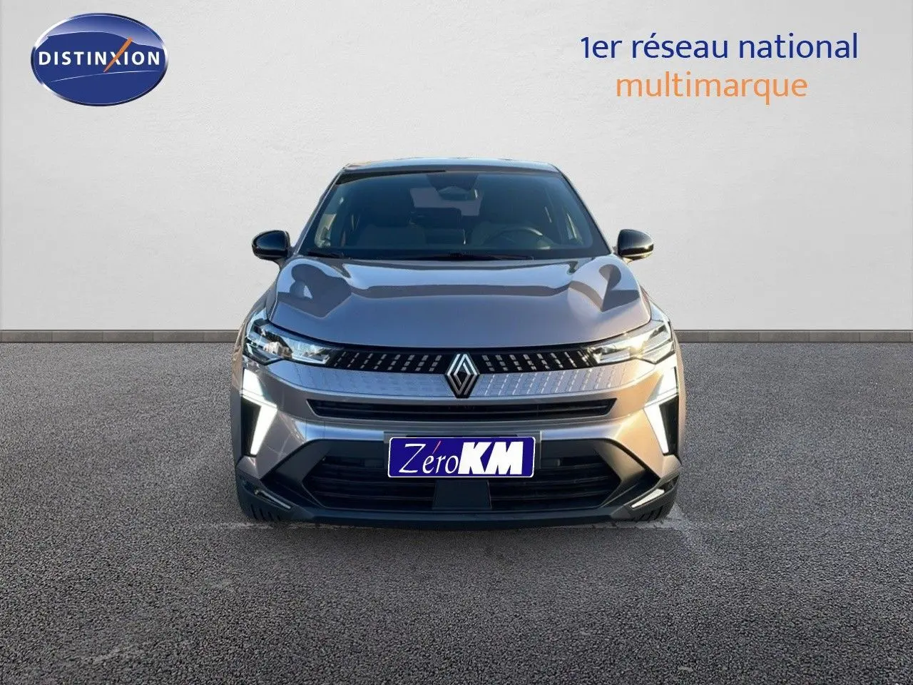 Vue frontale du Renault Captur E-Tech hybride gris cassiopée métal avec calandre et feux LED allumés.