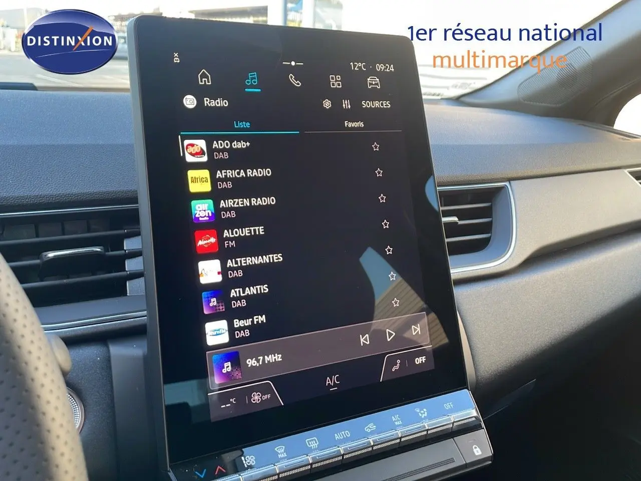 Écran tactile central allumé dans l'habitacle gris du Renault Captur E-Tech Hybrid 2025, côté droit visible.