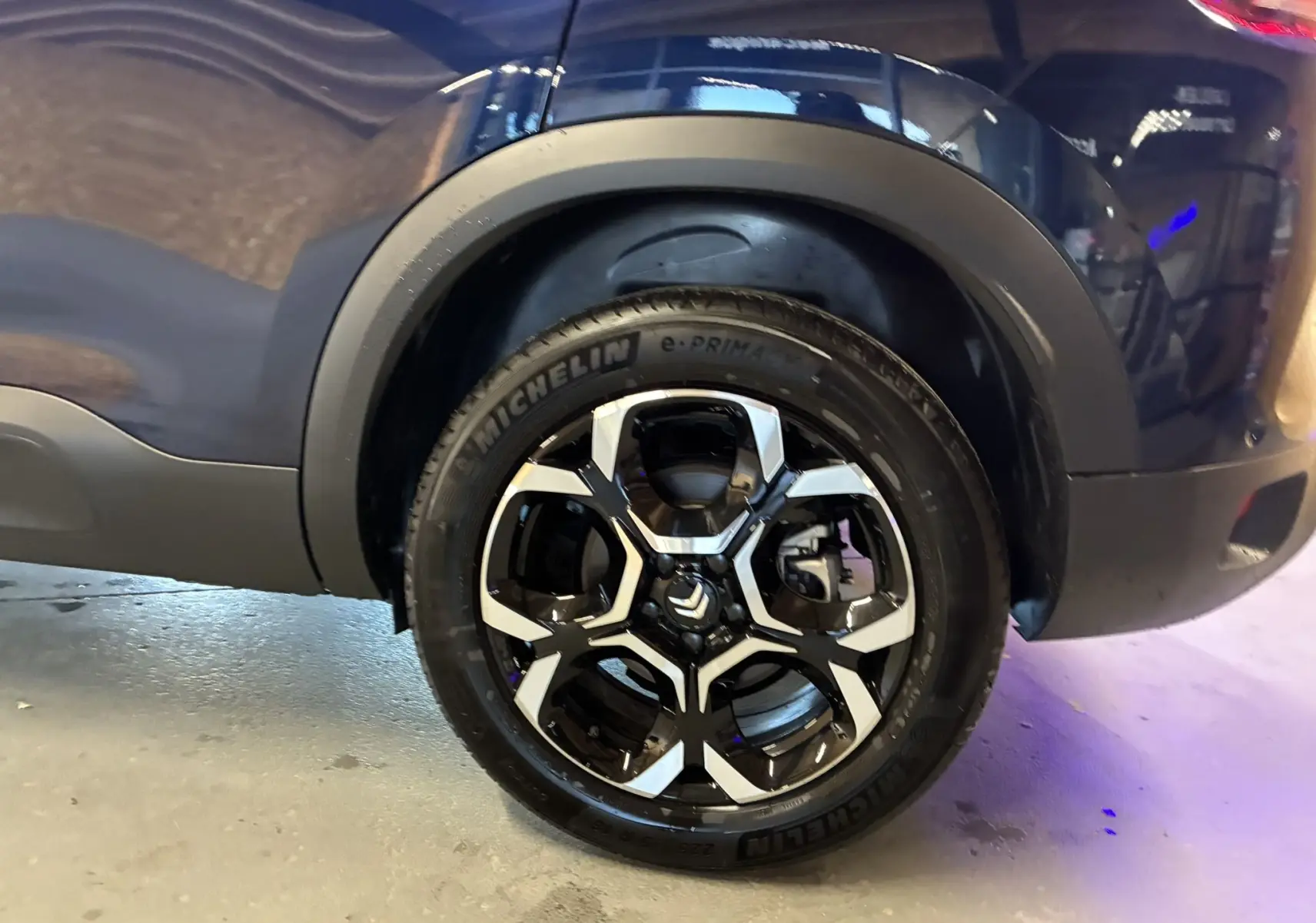 Gros plan sur la roue arrière droite d'un Citroën C5 Aircross bleu Eclipse Metal avec jante alliage noire et argentée.