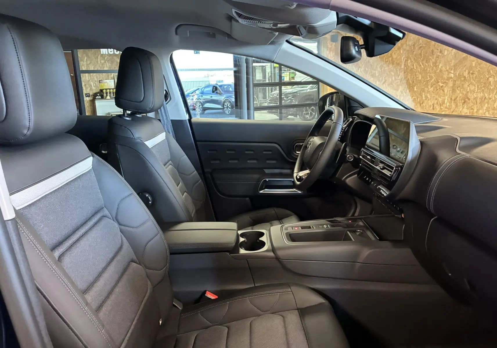 Vue intérieure côté conducteur du Citroën C5 Aircross 2025, sièges cuir noir et tableau de bord moderne.