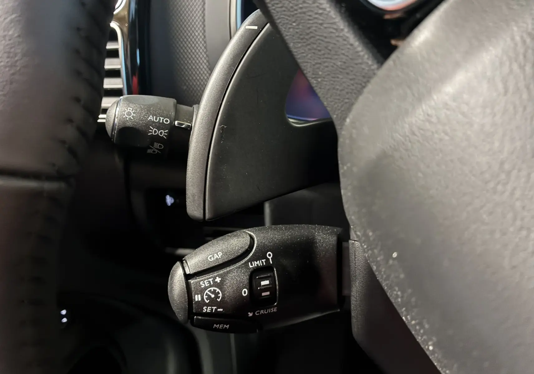 Gros plan sur la commande de régulateur de vitesse noire à gauche du volant d'un Citroën C5 Aircross 2025.