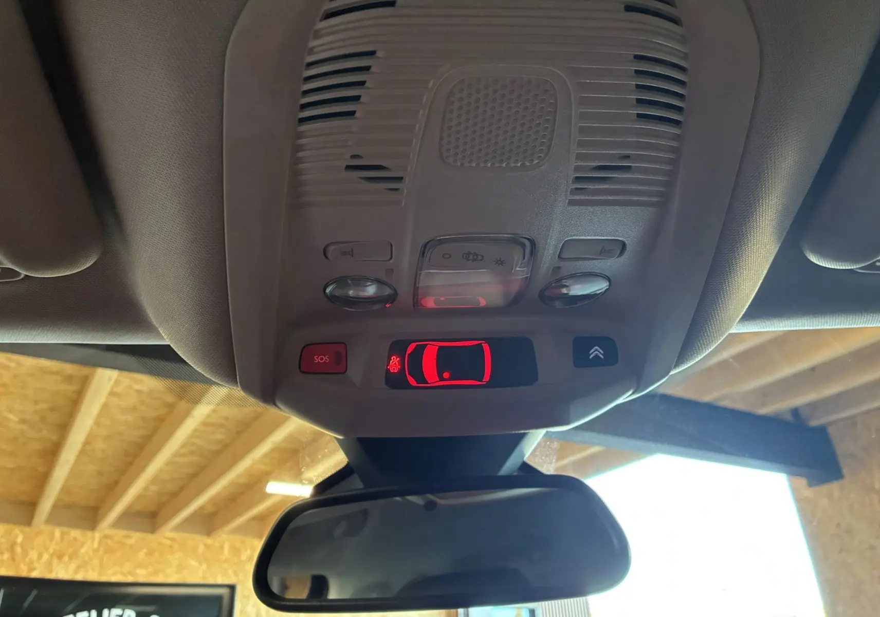 Vue intérieure du plafonnier du Citroën C5 Aircross 2025 avec commandes lumineuses et bouton SOS rouge.