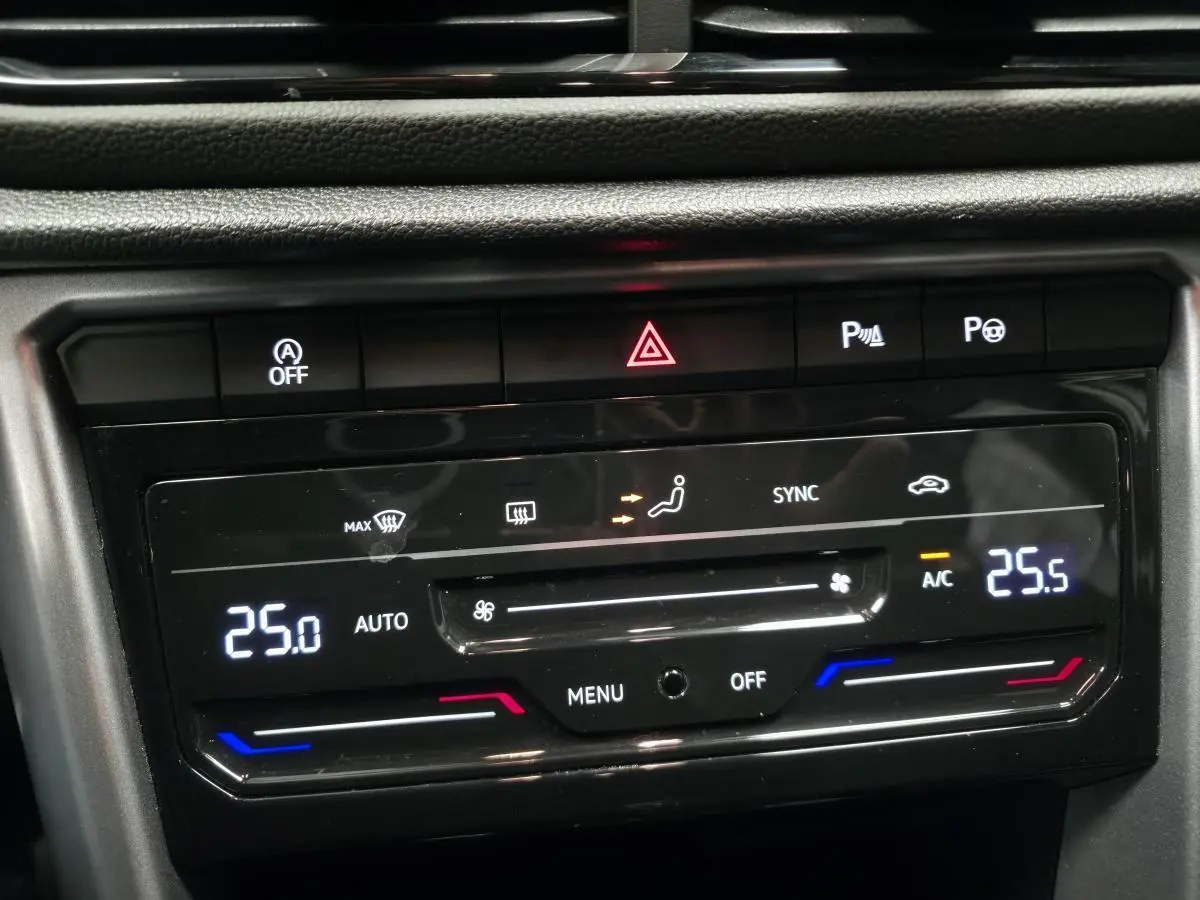 Panneau de commande de la climatisation bi-zone tactile du Volkswagen T-Roc blanc, affichant 25°C côté gauche et 25,5°C côté droit.