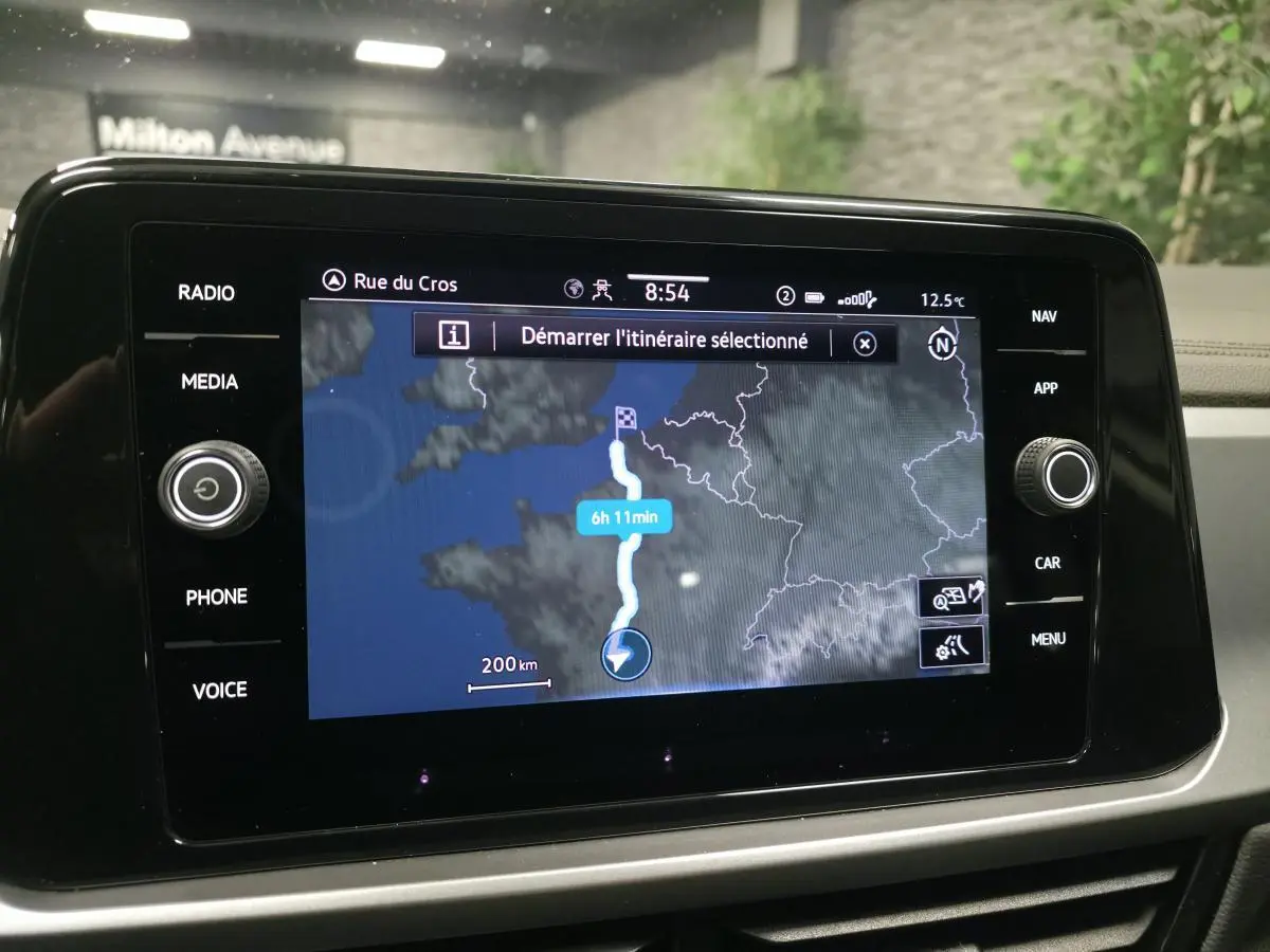Écran tactile 8 pouces du Volkswagen T-Roc blanc 2022 affichant la navigation avec itinéraire et options multimédia.