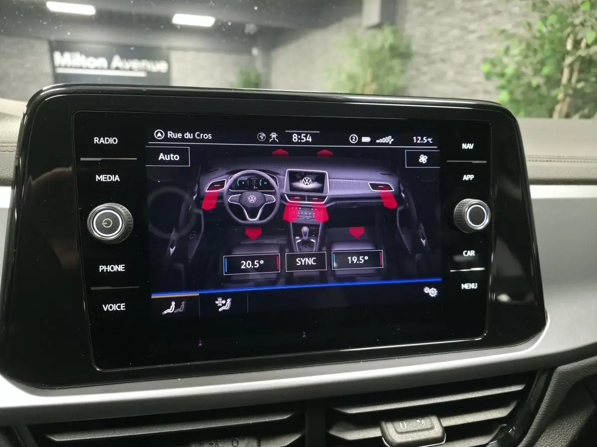 Écran tactile central du Volkswagen T-Roc blanc 2022 affichant la commande de climatisation bi-zone.