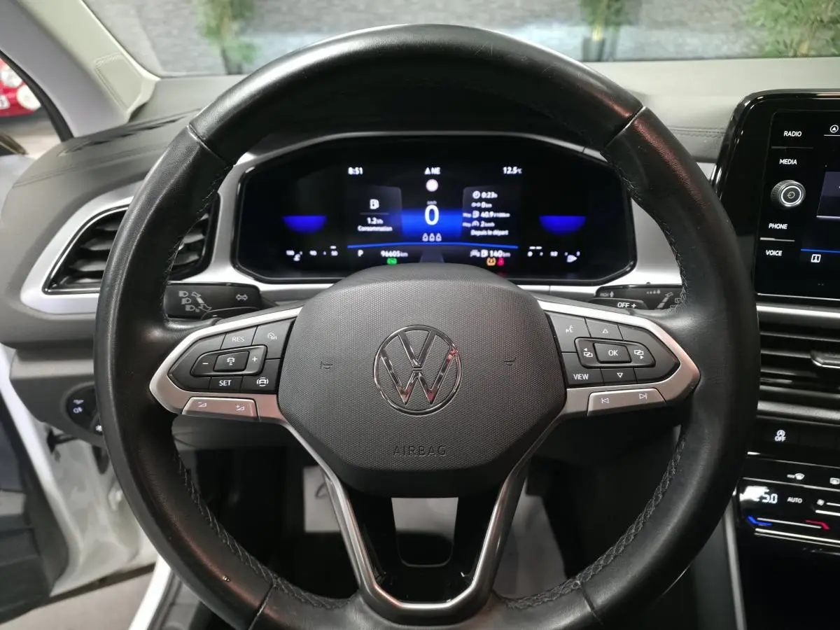 Vue rapprochée du volant cuir multifonction noir et du tableau de bord digital d'un Volkswagen T-Roc 2022.