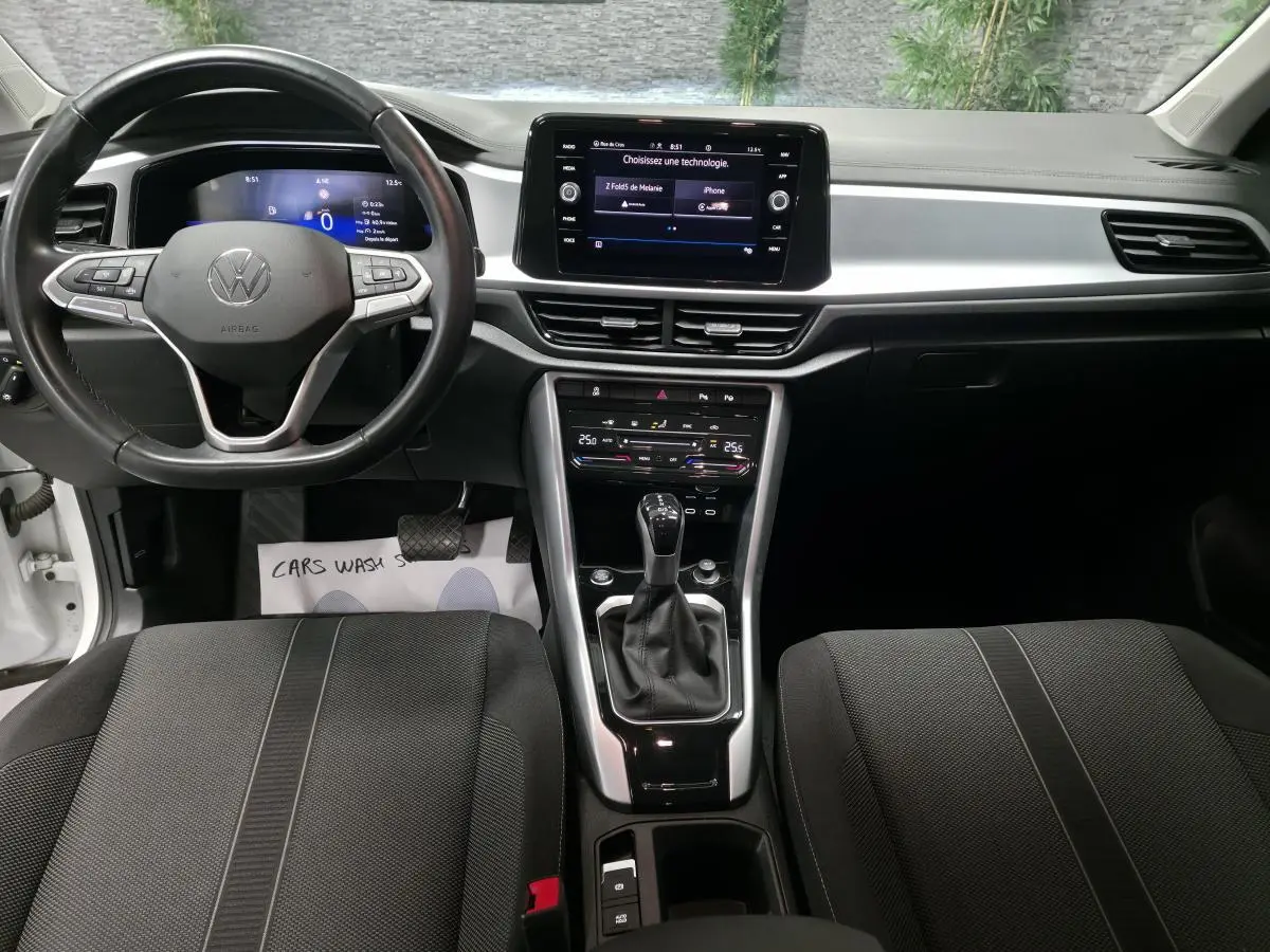 Vue intérieure avant du Volkswagen T-Roc 2022 avec tableau de bord digital, écran tactile 8 pouces et sellerie tissu noir.