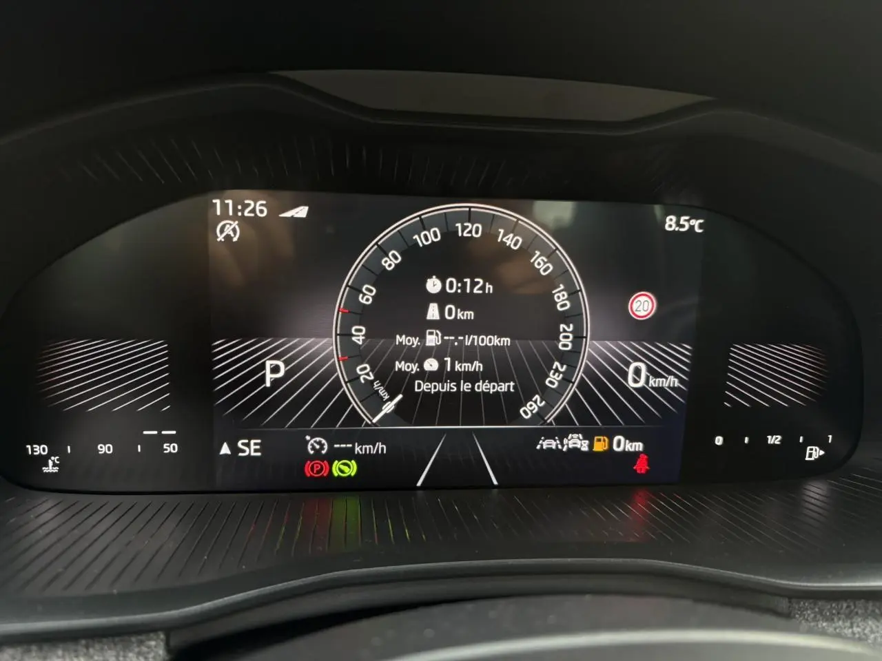 Affichage numérique du tableau de bord du Skoda Kamiq TSI 116 DSG7, montrant la vitesse et les alertes au repos.