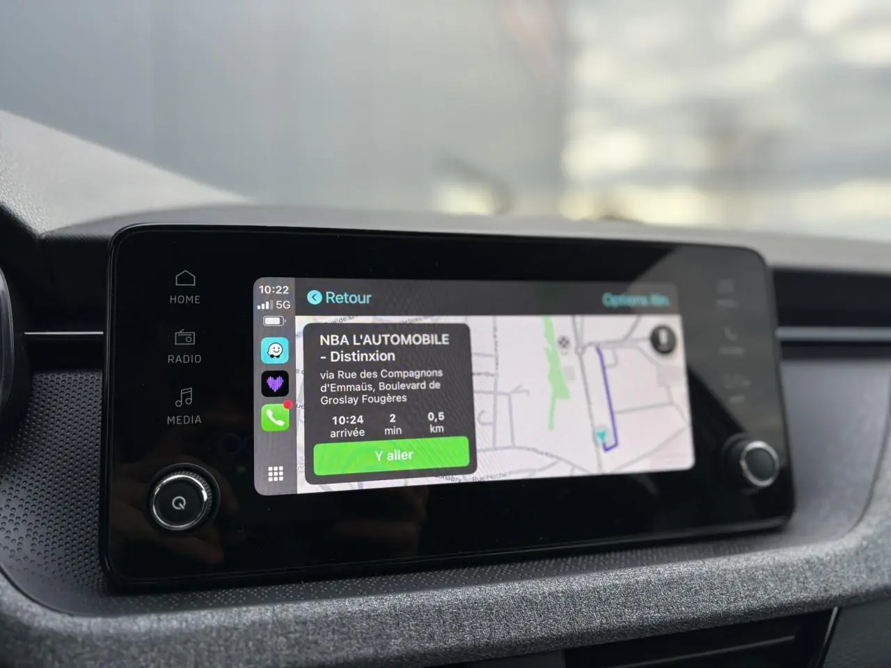 Écran tactile central du Skoda Kamiq 2025 affichant la navigation Apple Car Play avec carte et itinéraire.