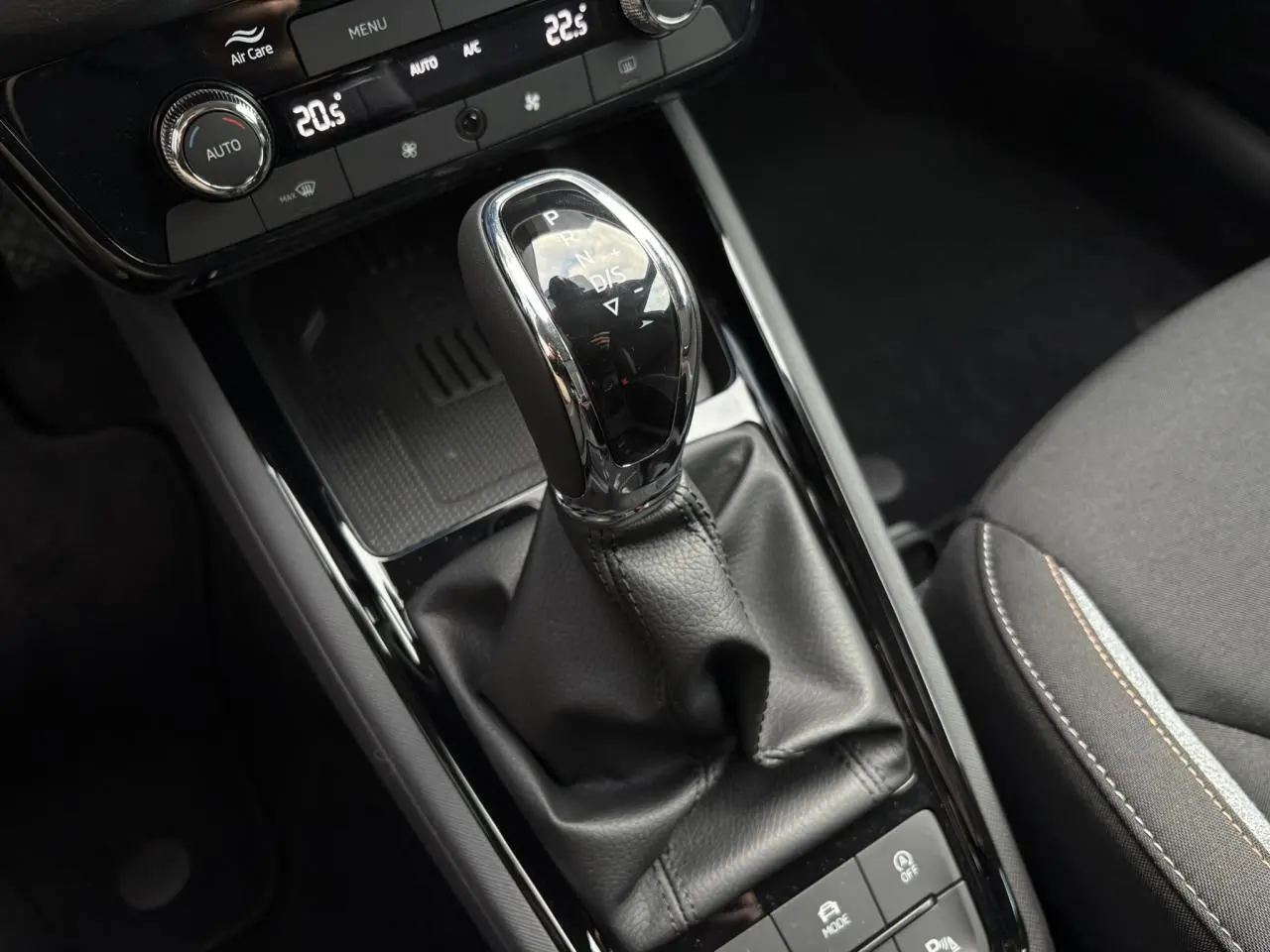 Le levier de vitesse automatique noir et chrome du Skoda Kamiq TSI 116 DSG7 avec console et siège tissu visible.