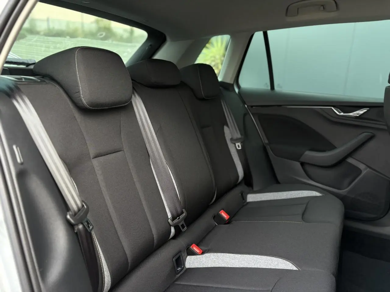 Vue latérale droite de la banquette arrière noire avec surpiqûres grises du Skoda Kamiq 2025.